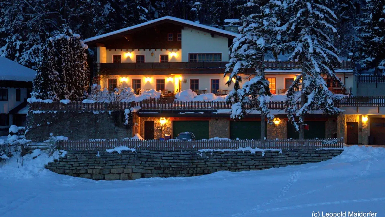 unser Haus im Winter in der Nacht, verschneit und beleuchtet
